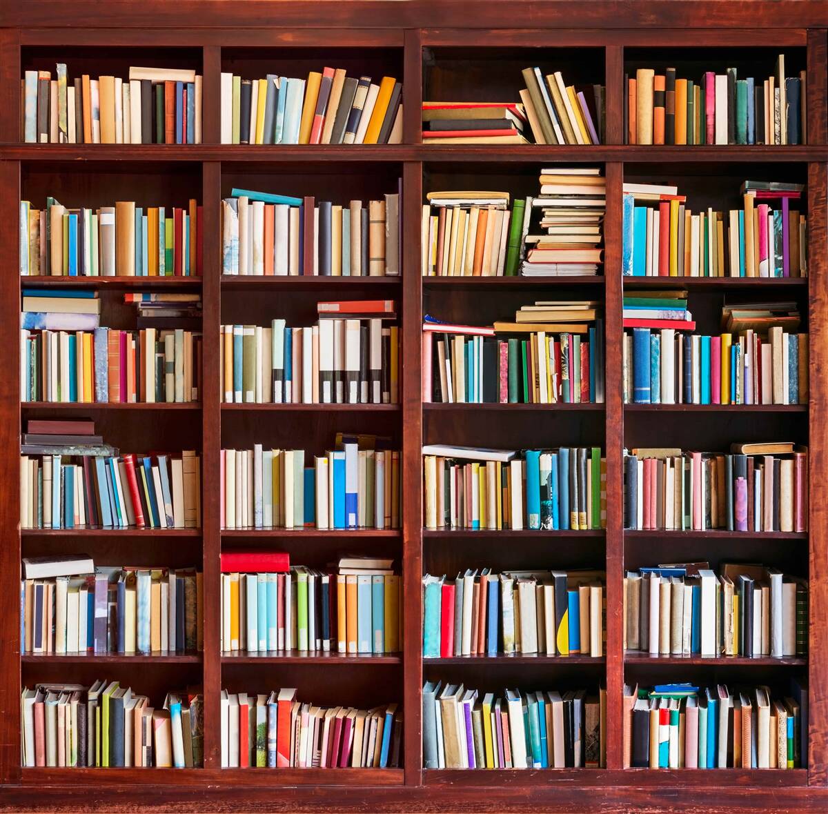 Fototapeten Bücherreihen in verschiedenen Farben in den Regalen