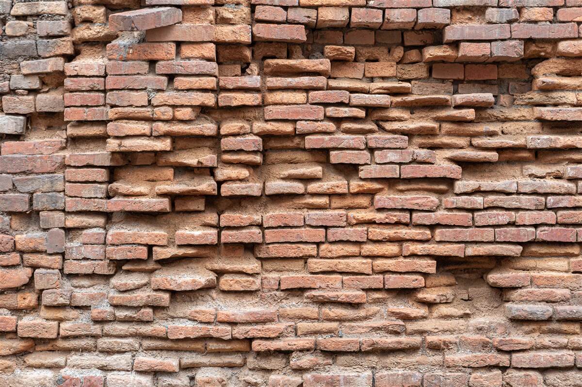 Fototapeten Steinmauer, die auseinander fällt