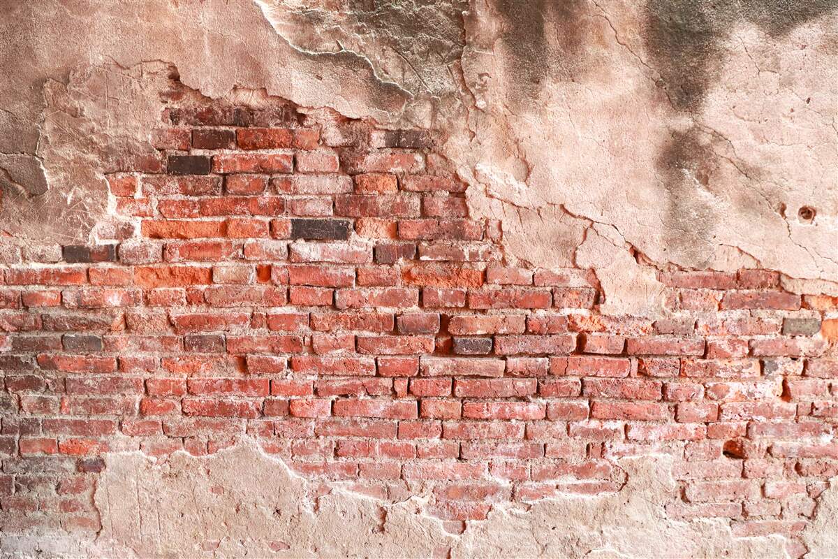 Fototapeten Eine mit zerkleinernde Ziegeln bedeckte Wand