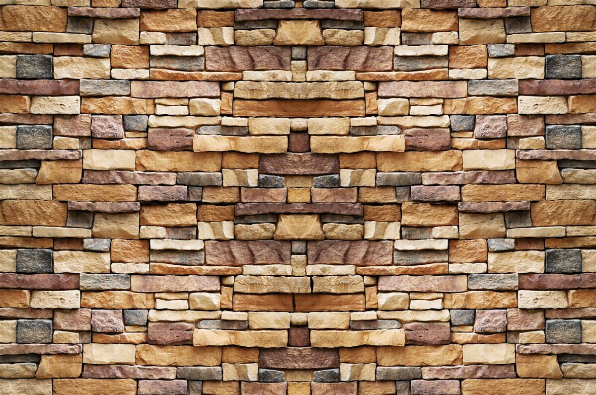 Fototapeten Eine Wand bestehend aus mehrfach gefärbten Steinen
