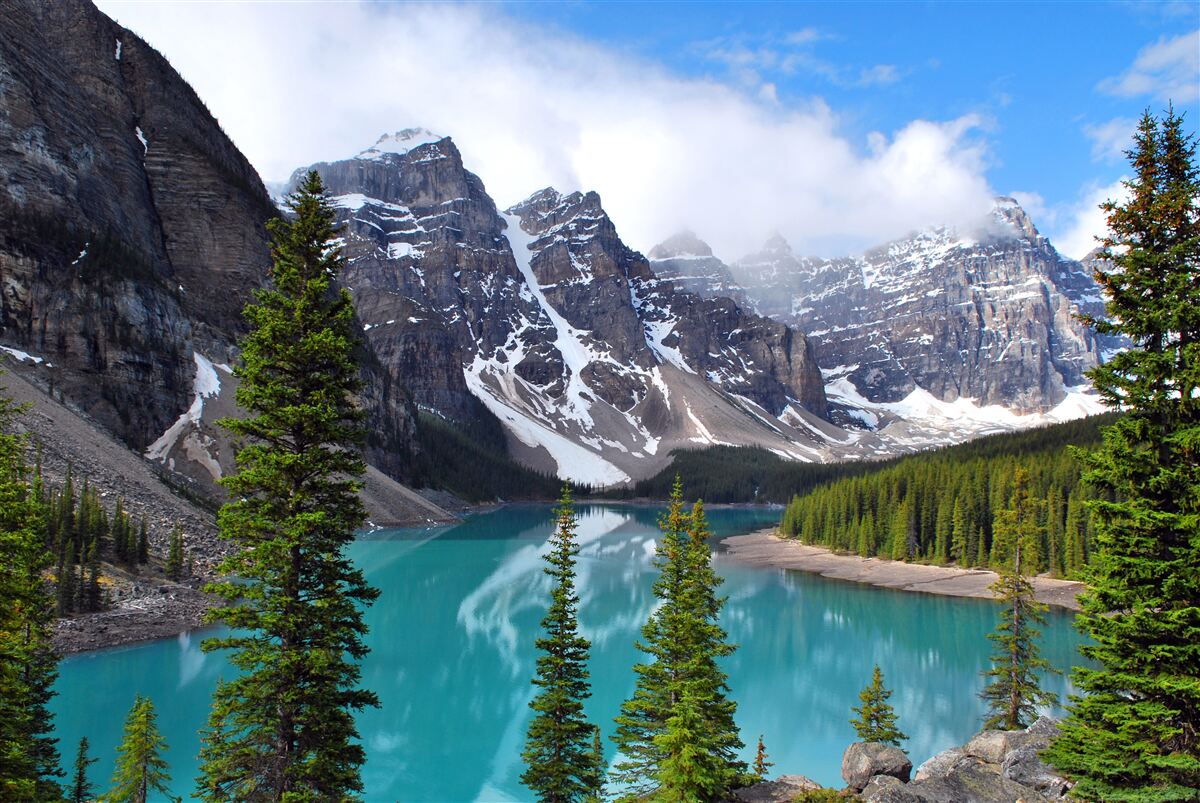 Fototapeten See mit blauem Wasser am Fuße der Berggipfel