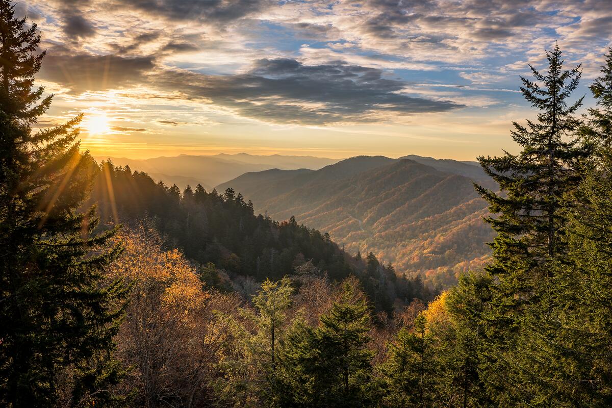 Fototapeten Die untergehende Sonne über den Berggipfeln