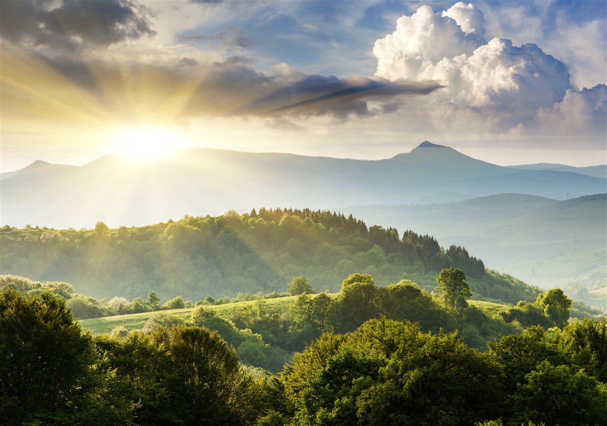 Fototapeten Morgenstrahlen der Sonne über den Berggipfeln