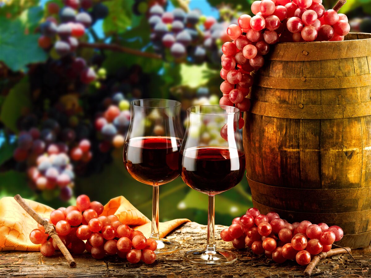 Fototapeten Die Traubenbälle sind ein Hintergrund für mit Wein gefüllte Brille