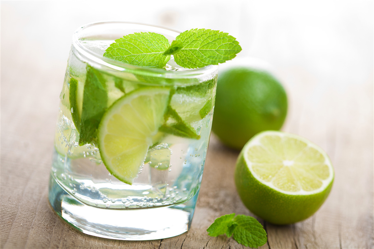 Fototapeten Ein Glas Wasser mit Limette und Minze