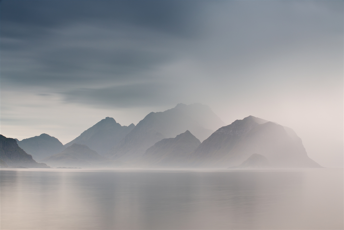 Fototapeten Dicker Nebel fällt ins Wasser, das zum Bergen führt