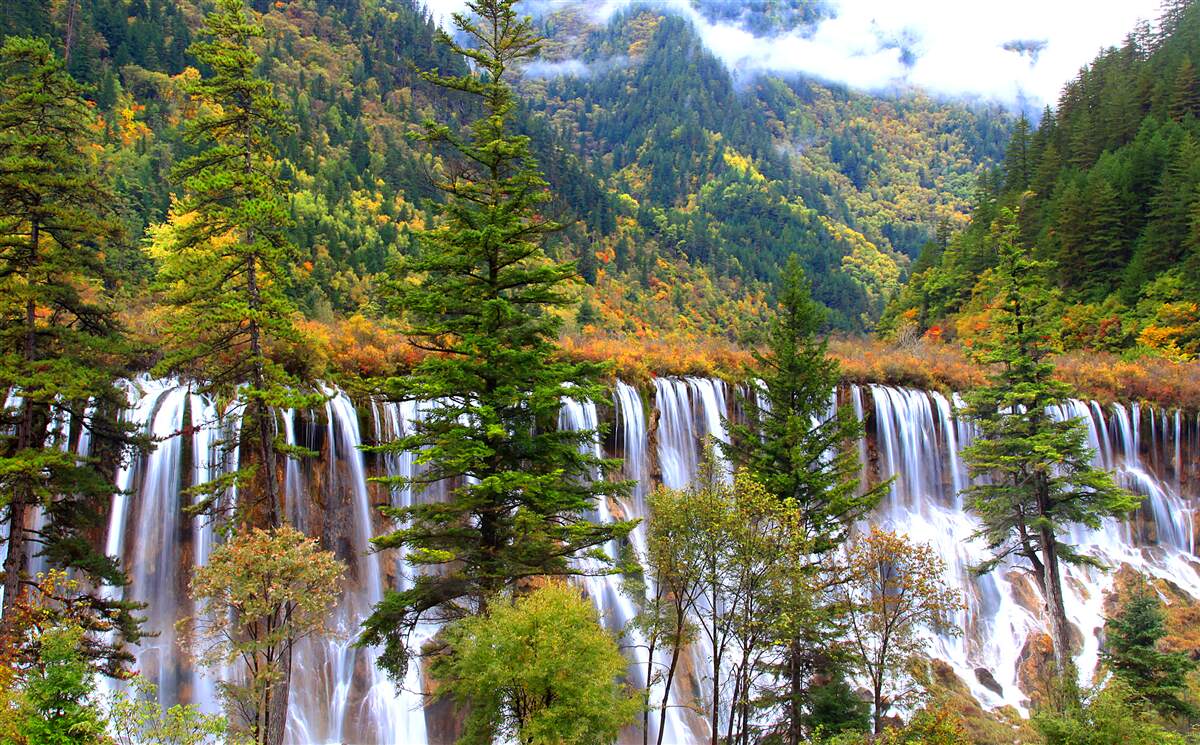 Fototapeten Ein riesiger Wasserfall, der über die Hänge der Berge fließt