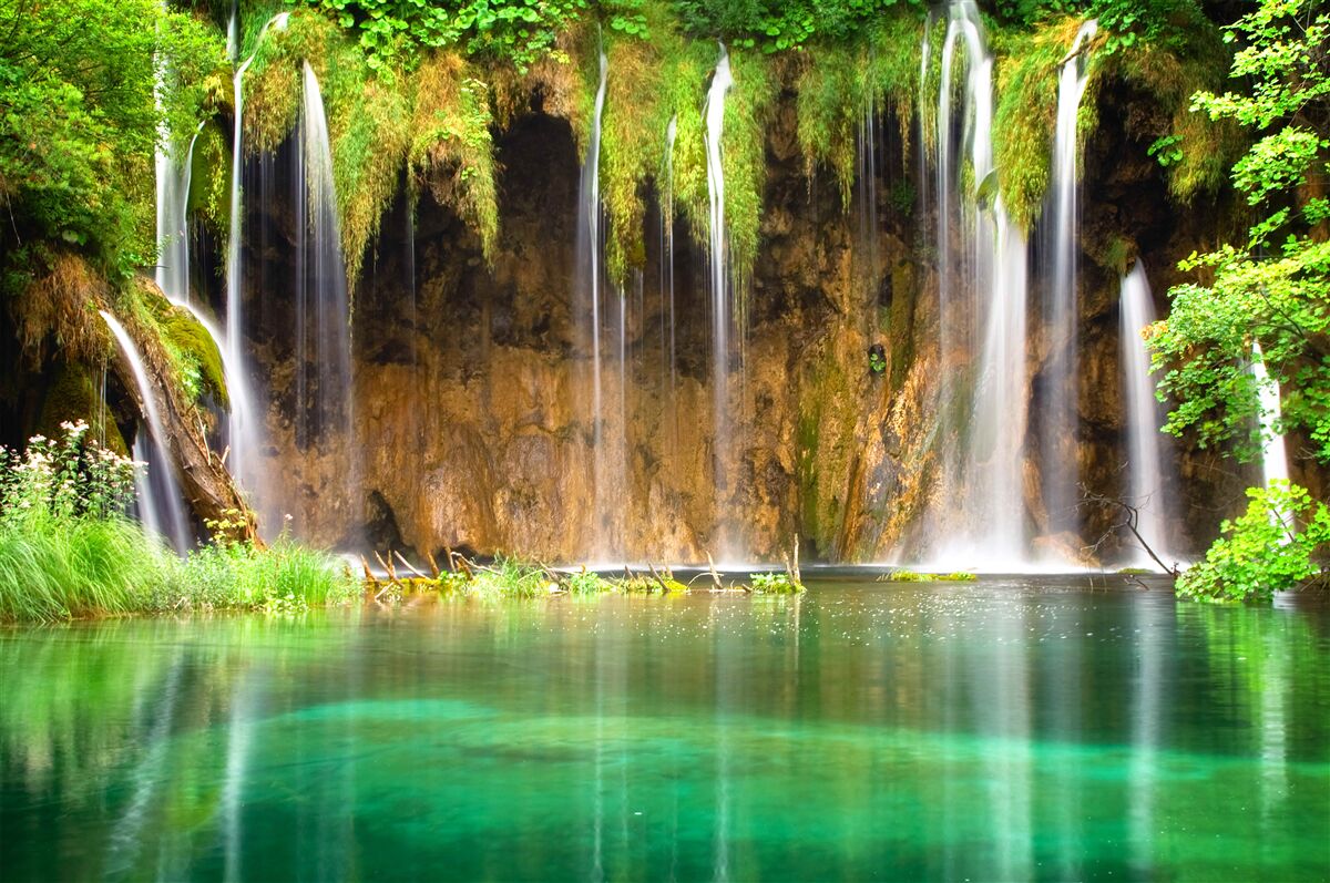 Fototapeten Ein charmanter Wasserfall in den Bergen