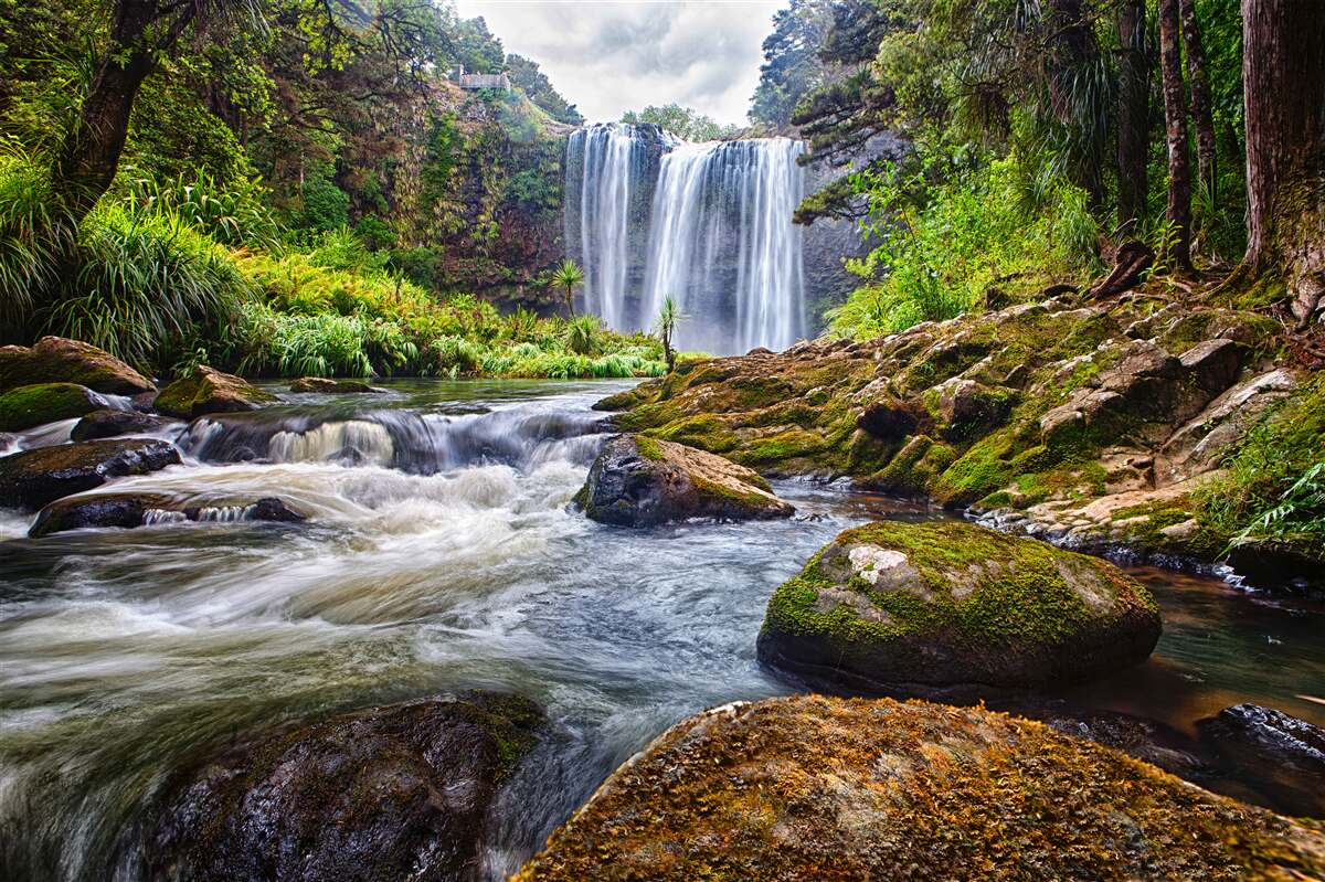Fototapeten Das laute Geräusch des Wasserfalls fällt von der Spitze des Berges