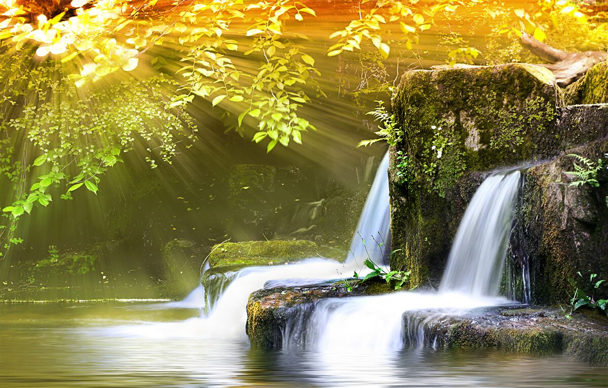Fototapeten Ein Wasserfall, der in die Sonnenstrahlen fällt