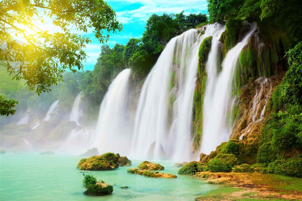 Fototapeten Ein lautes Wasserfall, der in der Sonne schimmert