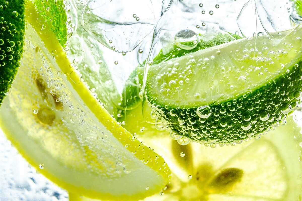 Fototapeten Zitronen- und Limettenscheiben in einem Glas Wasser