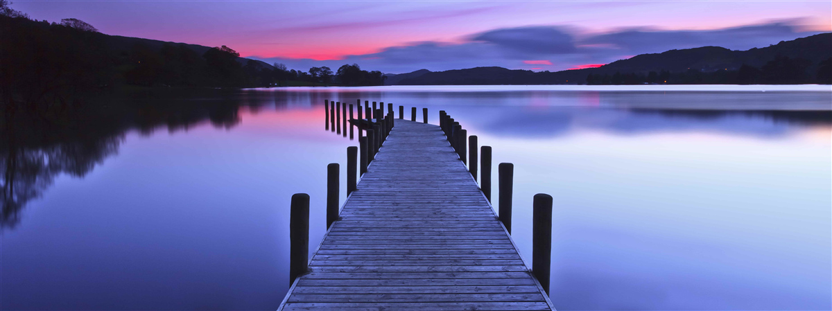 Fototapeten Pier in der Nähe des Sees in den Bergen im Morgengrauen