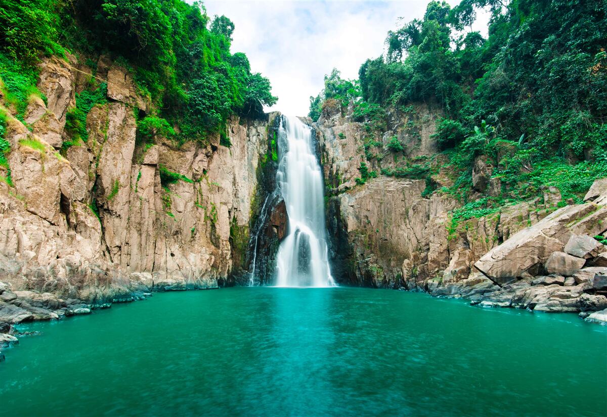 Fototapeten Der Hochwasserfall fällt in die Berge
