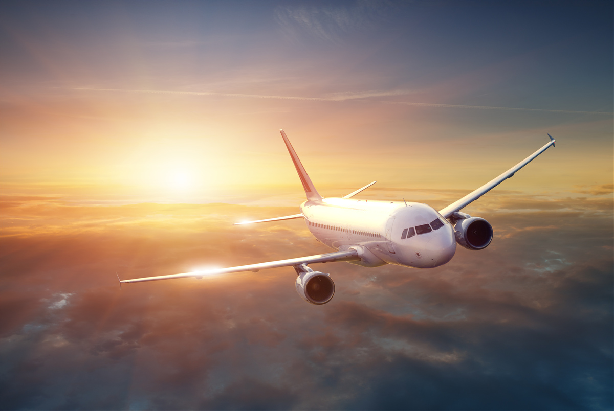 Fototapeten Das Flugzeug verschwindet im Sonnenuntergang