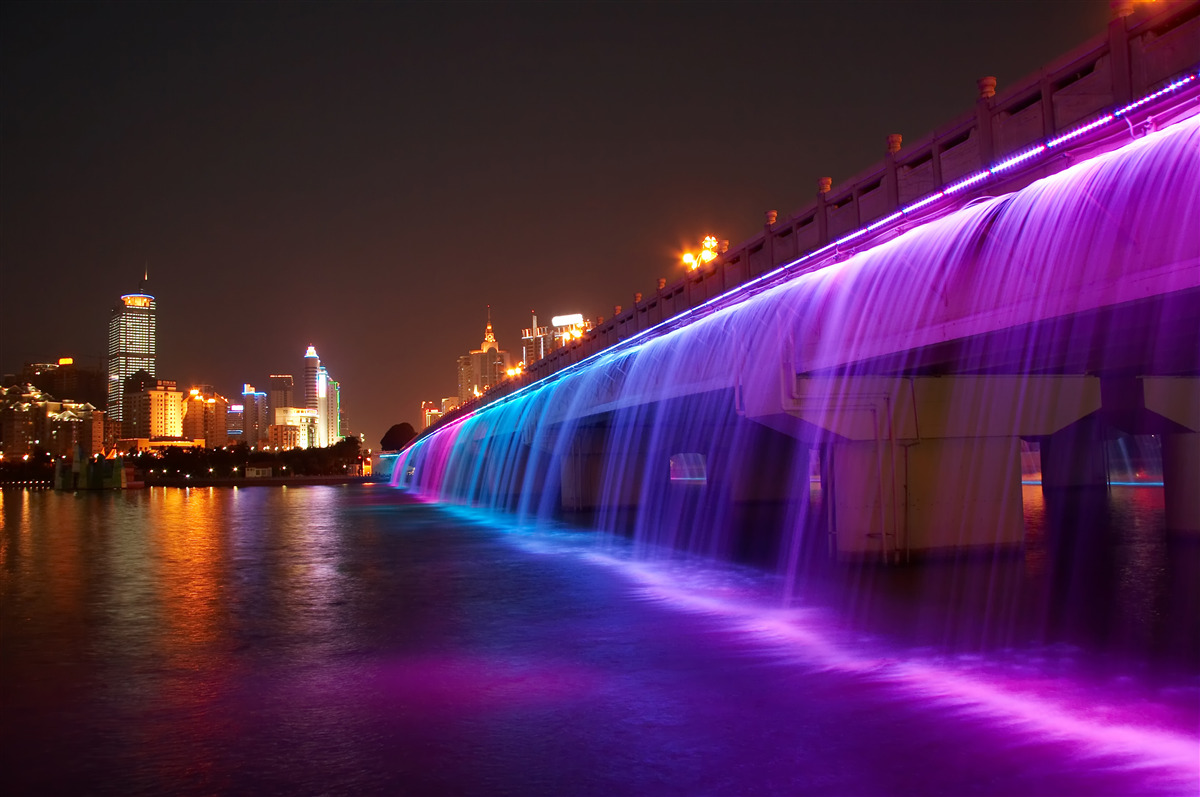 Fototapeten Leuchtende Wasserbeleuchtung in der Nähe der Brücke