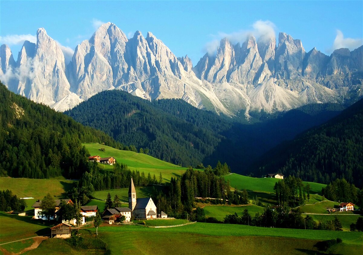Fototapeten Ein Dorf in einer Klärung am Fuße der Berge