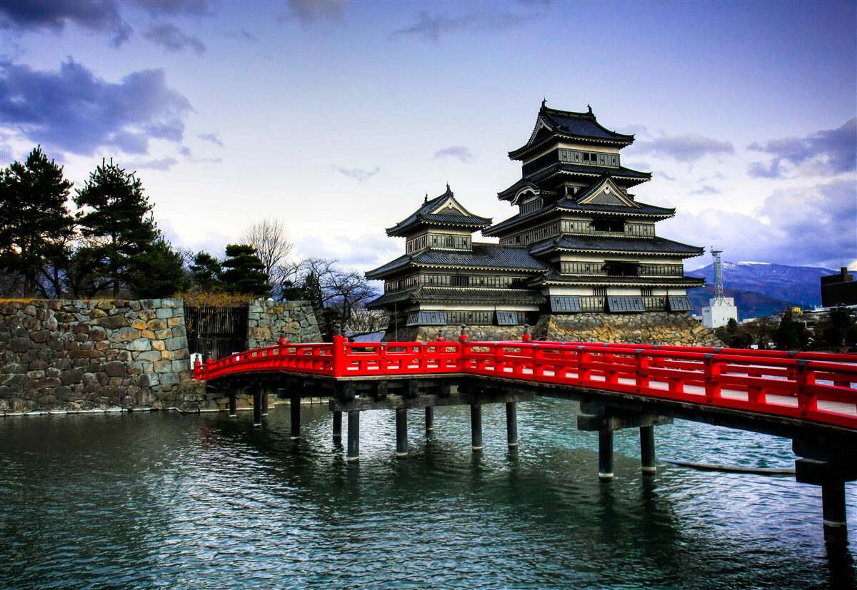 Fototapeten In Japan erstreckt sich die rote Brücke über den Fluss