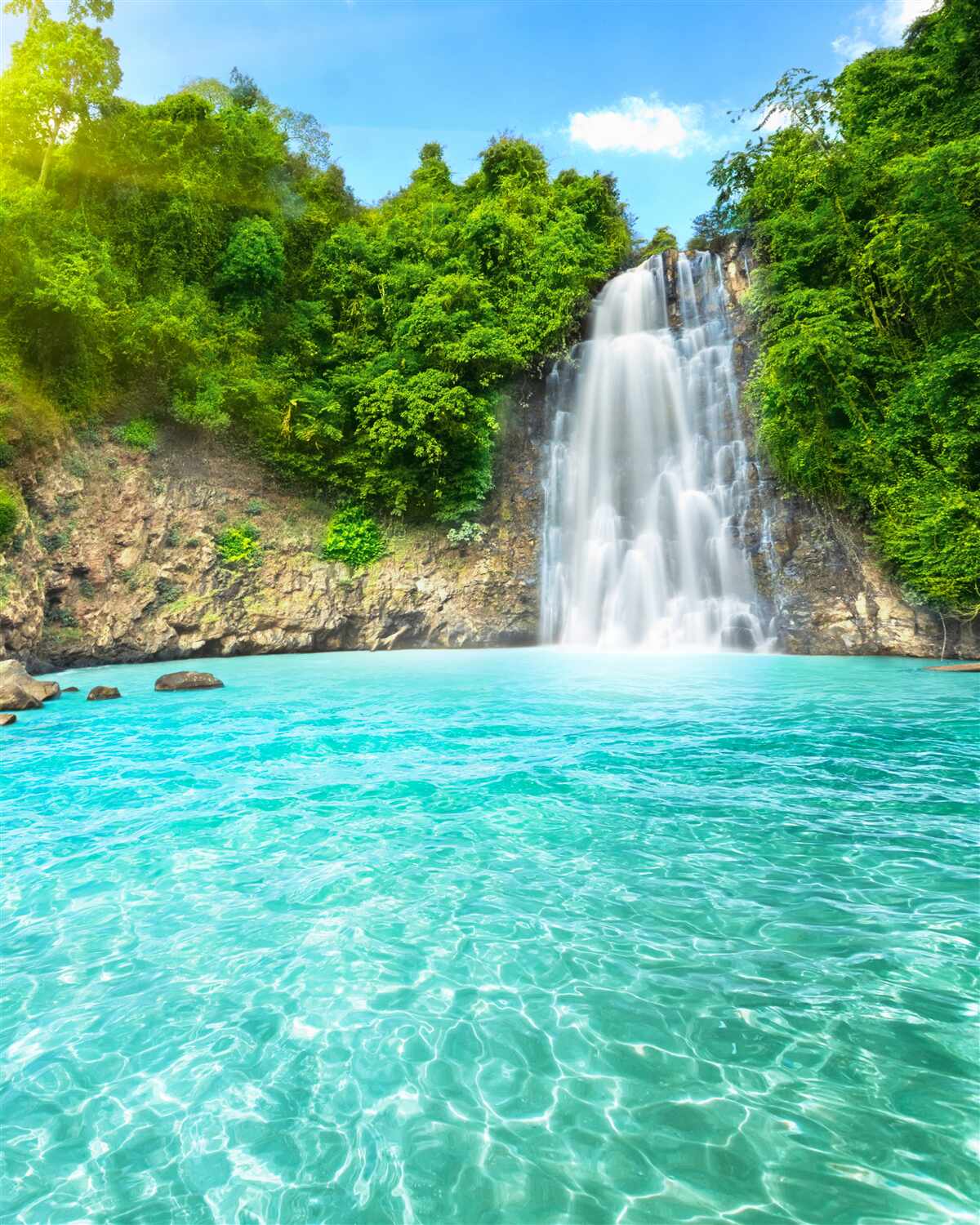Fototapeten Dankbarer Wasserfall fällt in den blauen See