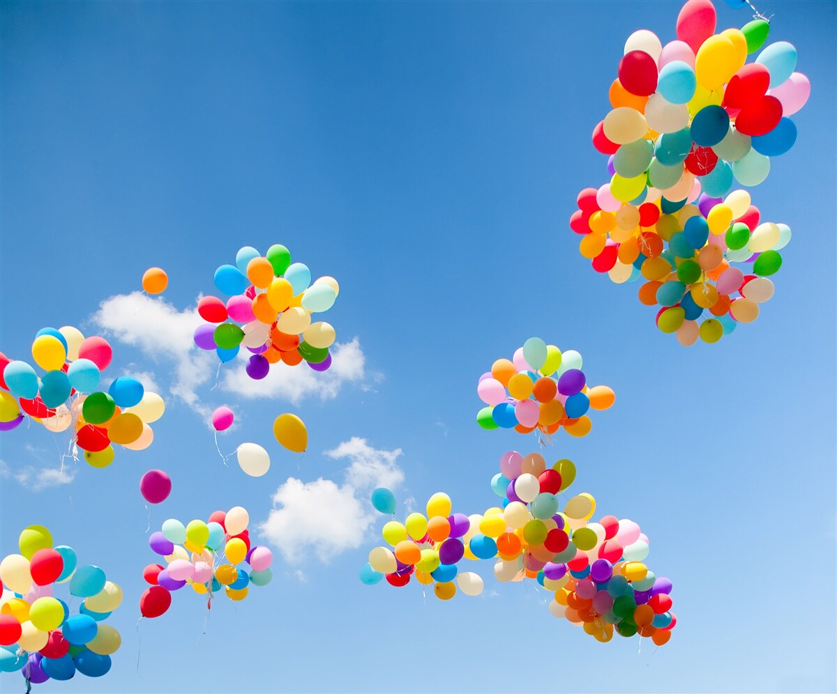 Fototapeten Hunderte von bunten Bällen erheben sich in den Himmel