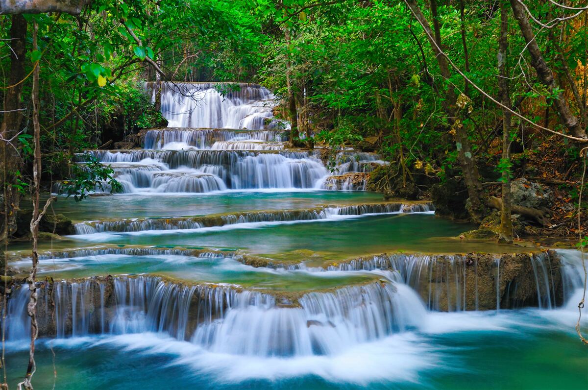 Fototapeten Großer Wasserfall mit türkisfarbenem Wasser, das eine Kaskade hinunter fließt