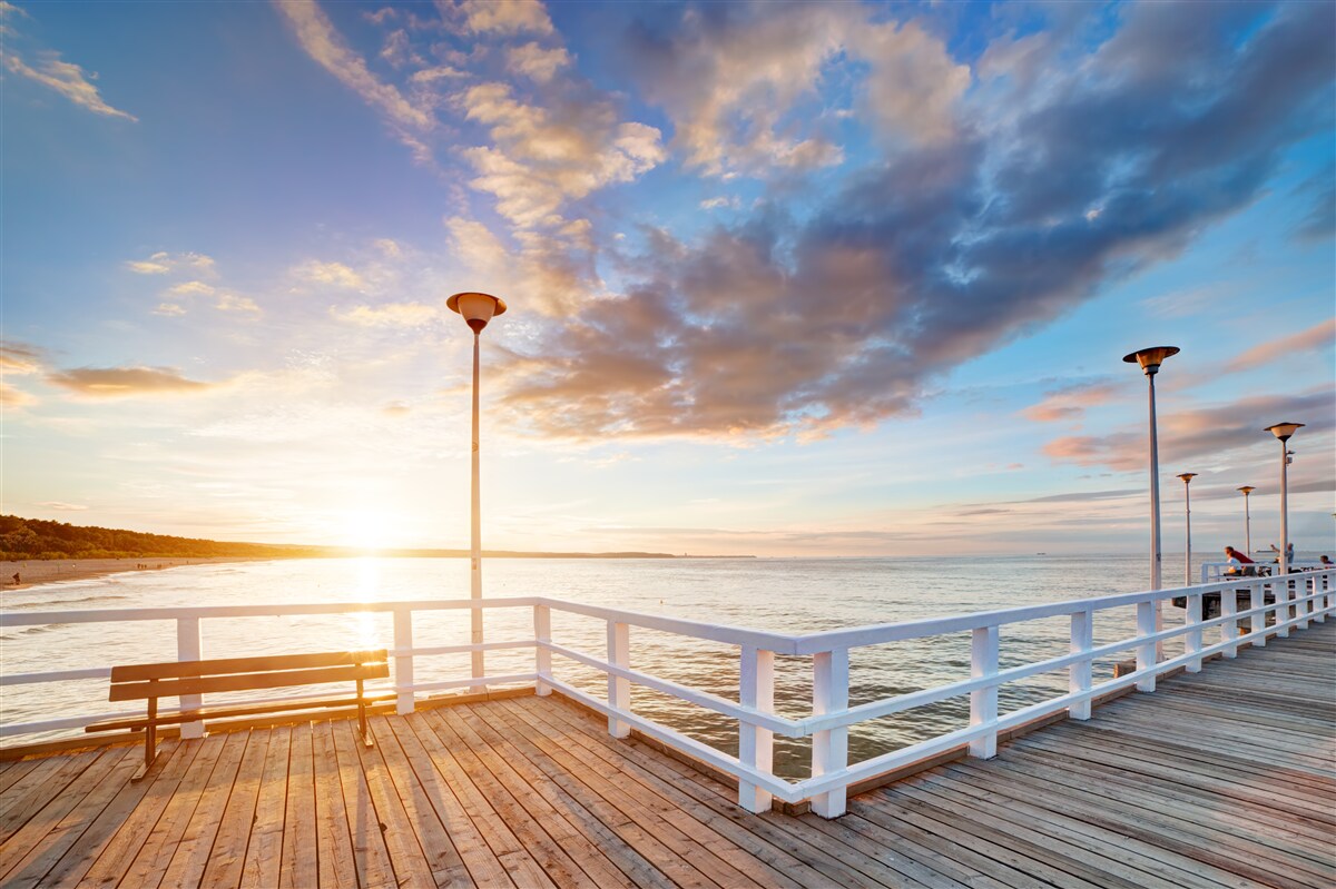Fototapeten Der verlassene Holzpier sieht die Sonne bei Sonnenuntergang