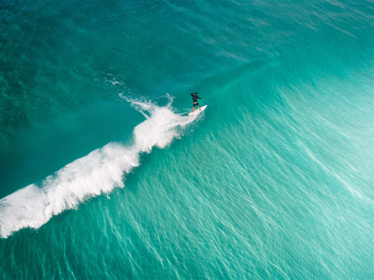 Fototapeten Einsamer Surfer im Unendlichkeit des Ozeans